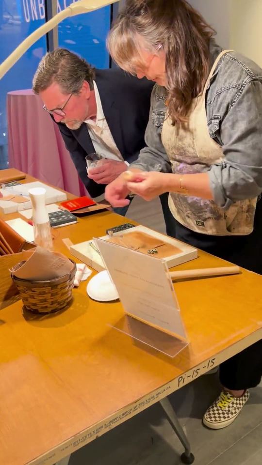Two guests stamping their leather notebooks