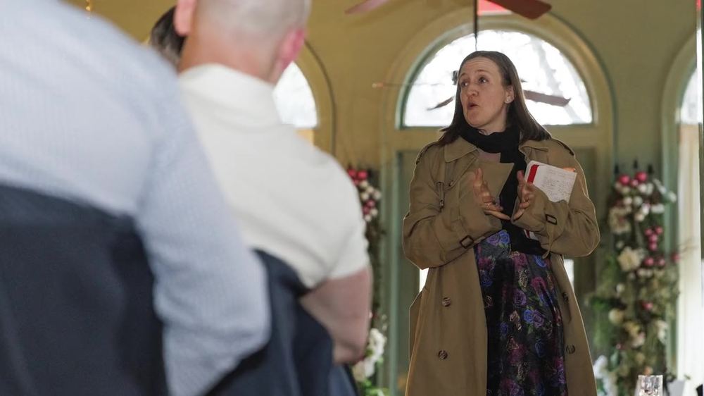 A host speaking to guests at dinner
