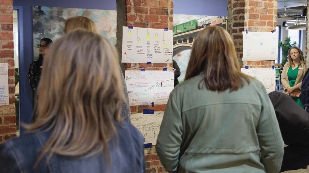 Guests reviewing posters on the wall during the gallery walk